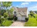 Beautiful two-story home with blue shutters, lush green lawn, and a two-car garage at 4612 Maple Crest Pl, Harrisburg, NC 28075