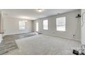 Spacious living room with neutral carpeting, bright natural light, and stylish wood-look flooring accents at 463 W Barr St, Lancaster, SC 29720