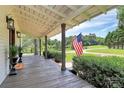 Spacious front porch with an American flag, wooden decking, and views of the landscaped front yard at 604 Ferguson Ridge Rd, Gastonia, NC 28052