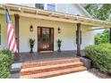 Inviting front porch with brick steps, wooden columns, and a classic wood front door at 604 Ferguson Ridge Rd, Gastonia, NC 28052