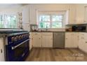 Bright kitchen with updated appliances, a blue oven, white cabinets, and a large window overlooking the yard at 613 E Ridge St, Kings Mountain, NC 28086