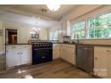 Updated kitchen features white cabinets, stainless steel appliances, a blue oven, and a bright, airy atmosphere at 613 E Ridge St, Kings Mountain, NC 28086
