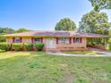 Charming brick home with well-manicured lawn and covered carport at 6416 Wilgrove Mint Hill Rd, Mint Hill, NC 28227