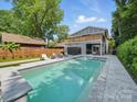 Backyard oasis with a large pool, spa, lounge chairs, and covered patio, perfect for outdoor entertaining and relaxation at 708 Cross Trail Dr, Charlotte, NC 28204
