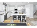 Stylish white kitchen featuring stainless steel appliances, an island with seating, and modern pendant lighting at 7220 Hodges Meadow Ln, Charlotte, NC 28213