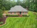 Charming brick home featuring a well-manicured front lawn and mature landscaping at 733 Killian Rd, Stanley, NC 28164