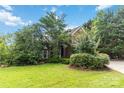 Charming brick home with a lush front yard and mature trees at 7704 Ninth Fairway Ln, Mint Hill, NC 28227
