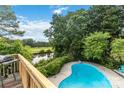 View from the deck of a pool with a golf course and pond in the background at 7704 Ninth Fairway Ln, Mint Hill, NC 28227