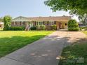 Long driveway leading to a charming brick home with lovely landscaping at 810 Surry Dr, Shelby, NC 28152