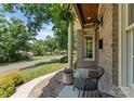 Cozy front porch with brickwork and a wrought iron chair at 901 Hartford Ave, Charlotte, NC 28209