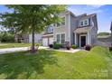 Inviting two-story home with a two-car garage, stone accents, and manicured lawn at 10012 Michael Crossing Dr, Charlotte, NC 28213