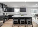 Modern kitchen featuring black cabinetry, stainless steel appliances, a kitchen island, and wood-look flooring at 10112 Florentine Ln, Charlotte, NC 28214