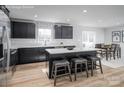 Modern kitchen featuring black cabinetry, stainless steel appliances, a kitchen island, and wood-look flooring at 10112 Florentine Ln, Charlotte, NC 28214