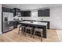 Modern kitchen featuring black cabinetry, stainless steel appliances, a kitchen island, and wood-look flooring at 10112 Florentine Ln, Charlotte, NC 28214