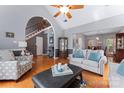 Open-concept living room showcasing hardwood floors, staircase, and cozy seating area with large windows at 107 Glenmont Ct, Mooresville, NC 28117