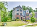 Exterior view of a two-story townhome featuring brick and siding with a well-maintained lawn at 12024 John Newton Dr, Davidson, NC 28036