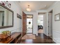 Inviting entryway with hardwood floors, mirror, and console table leading into a home office at 132 Hillston Ln, Mooresville, NC 28115