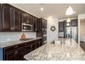 Modern kitchen featuring dark cabinets, granite counters, stainless appliances, and a kitchen island at 132 Hillston Ln, Mooresville, NC 28115