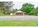 Charming single-story home with a covered front porch and neutral-colored siding, nestled among mature trees at 1529 Stony Point Rd, Shelby, NC 28150