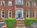 Close-up of the brick home's front entrance featuring an American flag and landscaped garden at 314 Southern Cross Ln, Matthews, NC 28105
