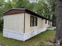 Side exterior view of the manufactured home with brown roof and siding at 326 Havencrest Ct, Gastonia, NC 28052