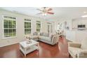 Open-concept living room with hardwood floors, modern sofa, lots of windows, and adjacent dining area at 3326 Park South Station Blvd, Charlotte, NC 28210