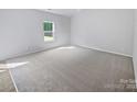 Bright bedroom with neutral carpet and a large window overlooking the backyard at 4122 Munson Dr, Charlotte, NC 28215
