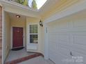Home entrance featuring a red door, sidelight window, and attached garage at 509 Settlers Grove Ln, Salisbury, NC 28146