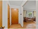 The entryway features a wooden front door, hardwood floors, and a glimpse into the spacious living room at 6207 Robinson Church Rd, Charlotte, NC 28215