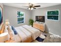 Well-lit bedroom with comfortable bed, modern dresser, and windows offering scenic views at 6208 Charlie Walker Rd, Kannapolis, NC 28081