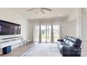 Bright living room with wood floors, modern entertainment center, and sliding glass doors to the backyard at 7651 Fenn Way, Fort Mill, SC 29707