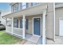 Inviting covered front porch with white railings and a blue front door at 7806 Mcgarry Trl, Charlotte, NC 28214