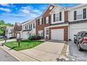 Beautiful townhome with a brick and siding exterior, neat landscaping, and attached garage at 8002 Mariners Pointe Cir, Denver, NC 28037
