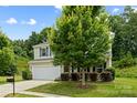 Traditional two-story home featuring a two-car garage, manicured lawn, and mature landscaping at 8400 Empress Ct, Charlotte, NC 28227