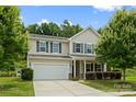 Charming two-story home with a two car garage, well-maintained lawn, and mature tree at 8400 Empress Ct, Charlotte, NC 28227
