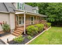 Charming home featuring a welcoming front porch with brown railings, landscaped yard and flowerbeds at 8632 Island Point Rd, Sherrills Ford, NC 28673