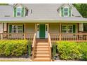 Home with a covered front porch, complemented by well-manicured landscaping and a welcoming green front door at 8632 Island Point Rd, Sherrills Ford, NC 28673