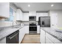 Modern kitchen with stainless steel appliances, granite countertops, and white cabinetry at 10127 Florentine Way, Charlotte, NC 28214