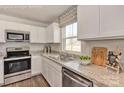 Bright kitchen featuring white cabinets, stainless steel appliances, and a granite countertop at 10127 Florentine Way, Charlotte, NC 28214