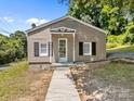 Charming single-story home boasts a welcoming front porch and sidewalk, enhancing curb appeal at 103 Garfield Ave, Albemarle, NC 28001