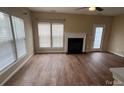 Spacious living room featuring a fireplace, ceiling fan, multiple windows, and wood flooring at 12378 Swan Wings Pl, Huntersville, NC 28078