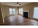 Spacious living room featuring a fireplace, ceiling fan, multiple windows, and wood flooring at 12378 Swan Wings Pl, Huntersville, NC 28078