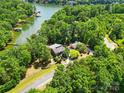 Stunning aerial view of a waterfront property surrounded by lush trees and a serene lake at 16525 Tulloch Rd, Charlotte, NC 28278