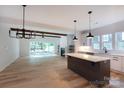 Open-concept floorplan with hardwood floors and a seamless transition from the modern kitchen to a light-filled living area at 1724 Dallas Ave, Charlotte, NC 28205