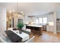 Modern kitchen with white cabinets, stainless steel appliances, an island with seating, and wood flooring at 1728 Dallas Ave, Charlotte, NC 28205