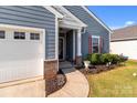 Home exterior featuring a covered entryway, attached garage, and manicured landscaping at 185 Willow Valley Dr, Mooresville, NC 28115