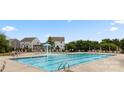 Community pool with a cascading water feature, surrounded by chairs and greenery for a relaxing atmosphere at 185 Willow Valley Dr, Mooresville, NC 28115