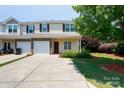 Inviting townhome showcasing a one-car garage, stone details, and a neatly landscaped yard at 2180 Shady Pond Dr, Clover, SC 29710