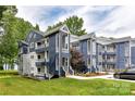 Modern condo exterior with blue siding, multiple balconies, and well-maintained landscaping at 303 Northwest Dr, Davidson, NC 28036