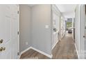 Bright hallway featuring wood-look floors, neutral walls, and a view into the living area at 303 Northwest Dr, Davidson, NC 28036